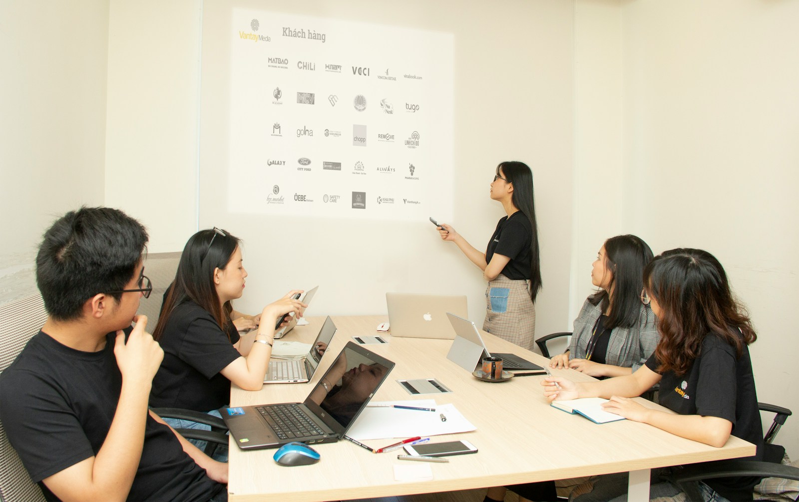 woman standing near projector screen showing what Effective Communication Strategy looks like