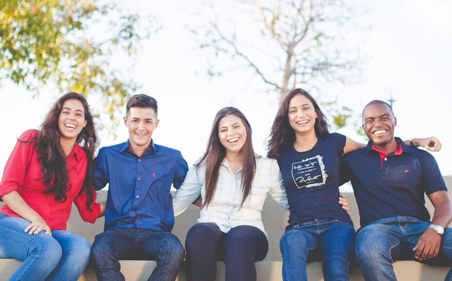 group of people sitting on bench near trees duting daytime